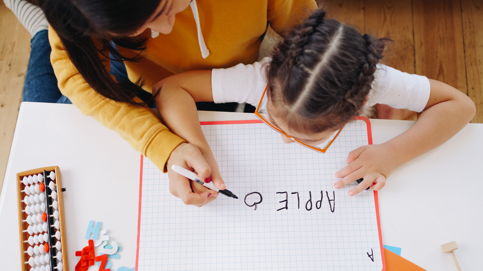 parent and child practicing print awareness, one of six skills needed before phonics instruction. 